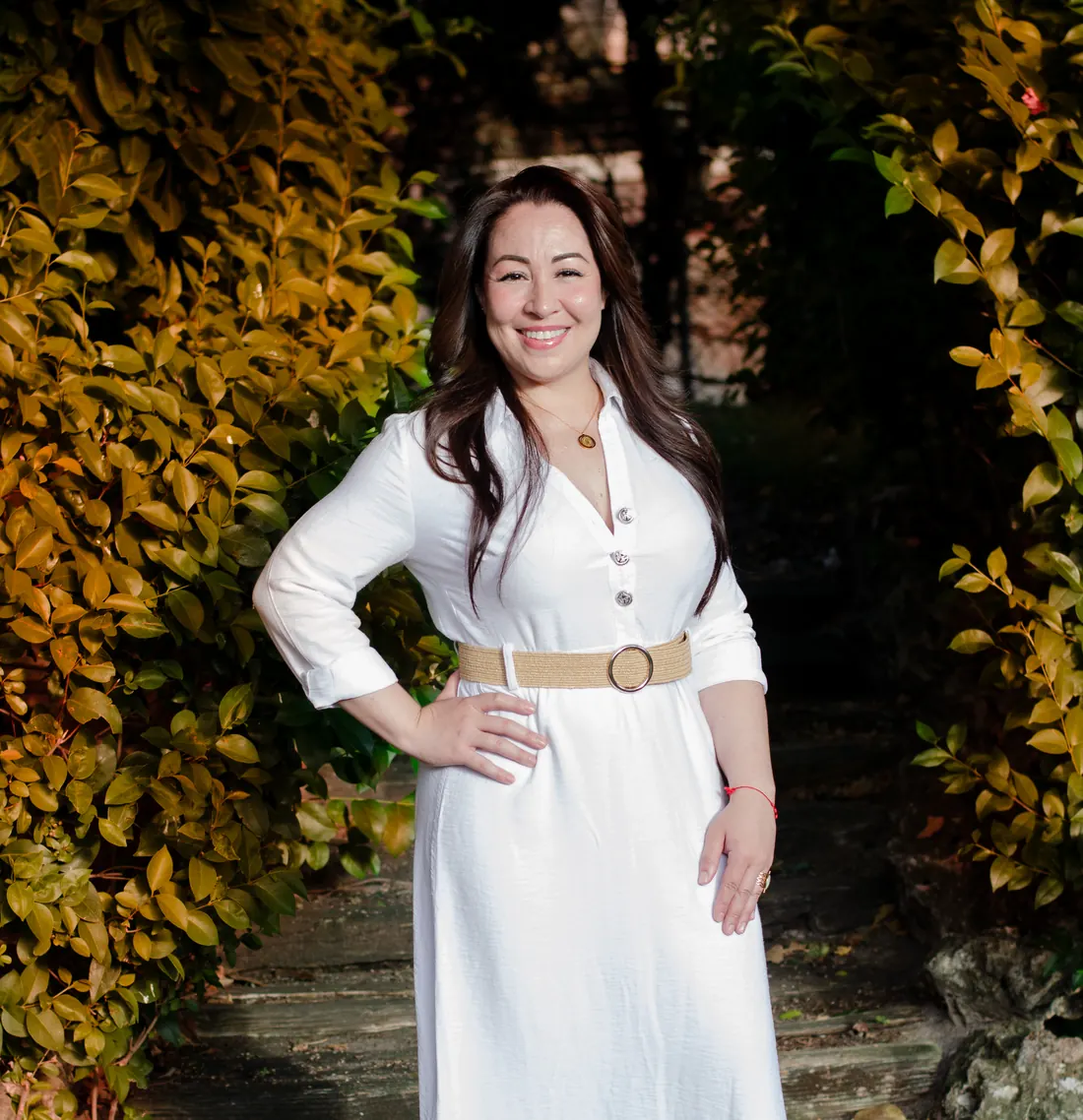 Clara Arias, coach de vida de Clariscoach, sonriendo en un jardín